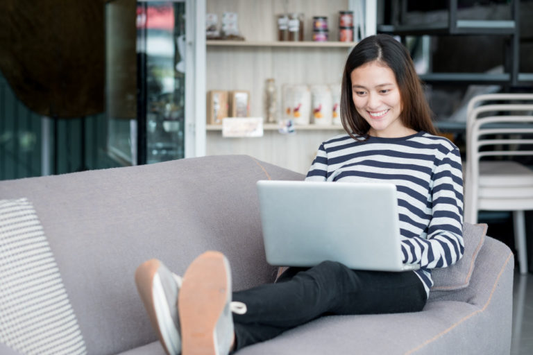 entrepreneur seated at a comfy sofa while interacting with her customers